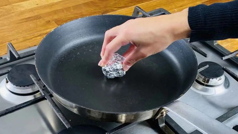 ¿Por qué es inteligente frotar una bola de papel de aluminio en la sartén?